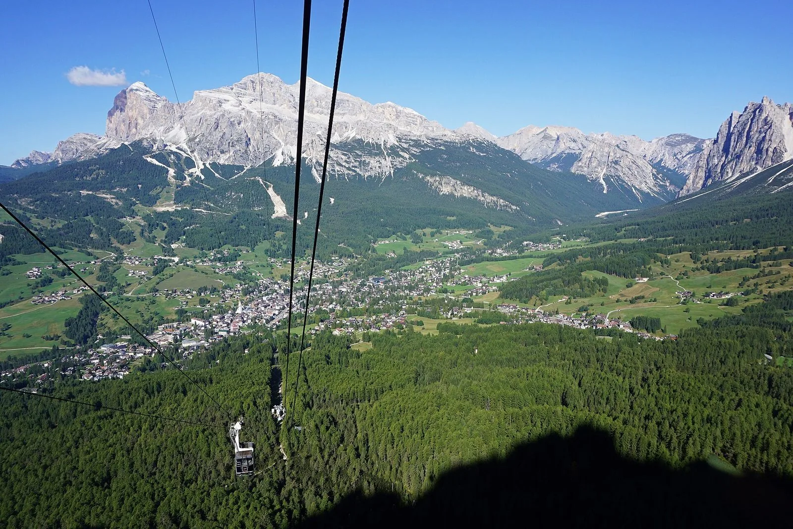 Vista dalla funivia del Faloria sulla conca di Cortina d'Ampezzo, con i boschi, il paese e le Tofane sullo sfondo