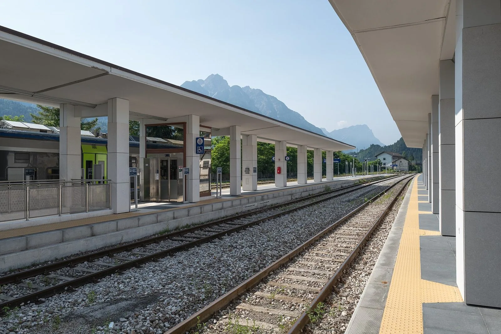 Binari e pensiline della stazione di Calalzo-Pieve di Cadore-Cortina con le montagne del Cadore sullo sfondo